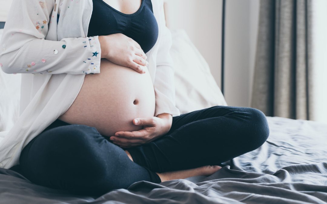 Belly of pregnant woman with hands