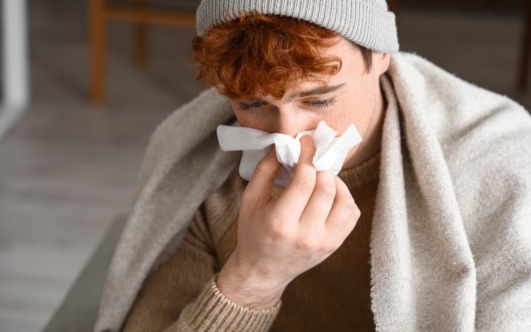 young man with runny nose at home, closeup