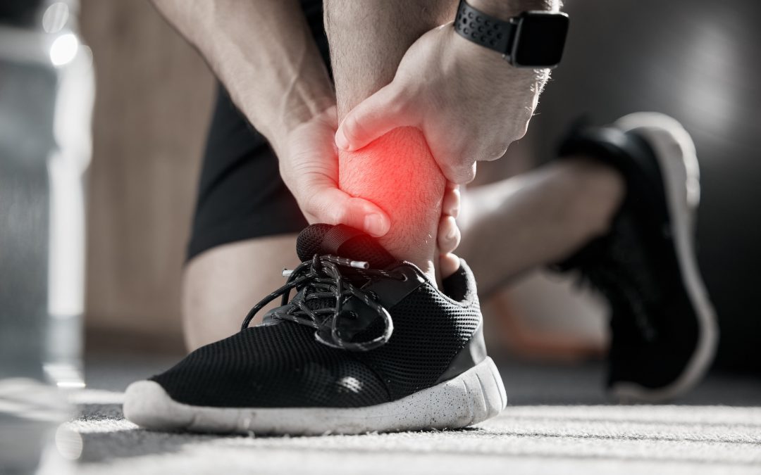 a man holds his injured ankle