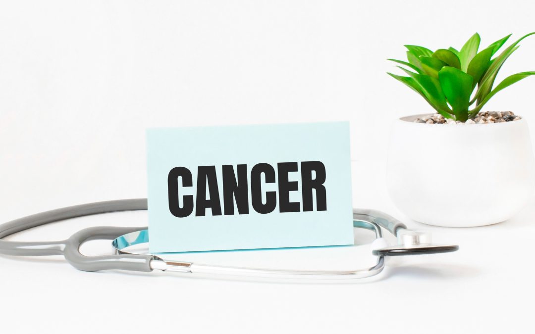 CANCER word on notebook, stethoscope and green plant