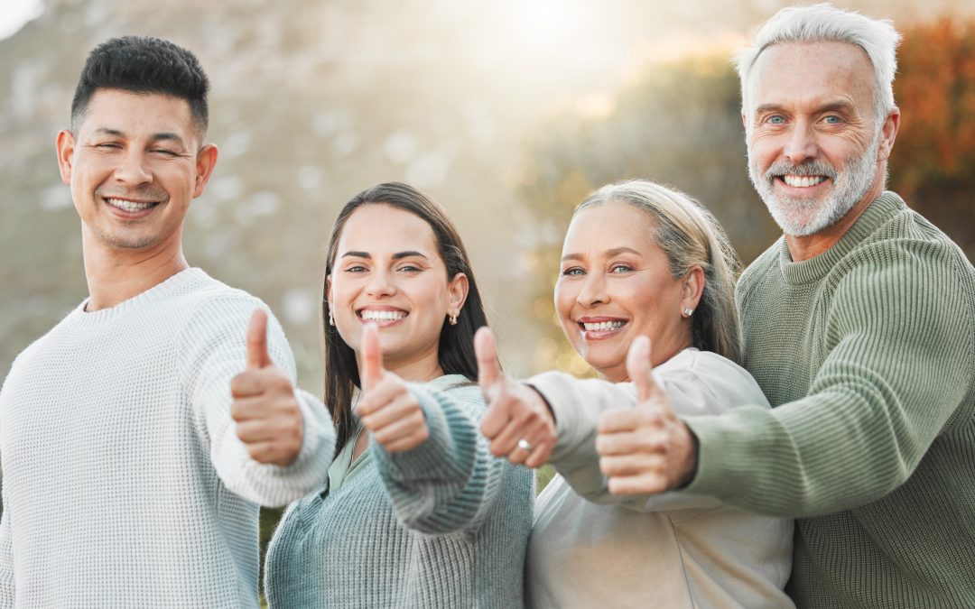 Four people extending hands with a thumbs up